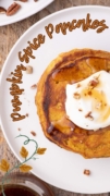 A while plate overhead shot of a ppumpkin pancake topped with whipped cream and pecans.