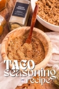 Taco Seasoning Recipe of a wood bowl with a wooden spoon in the seasoning.