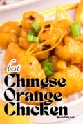 Best Chinese Orange Chicken close up shot garnished with zest and green onions and served over white rice.