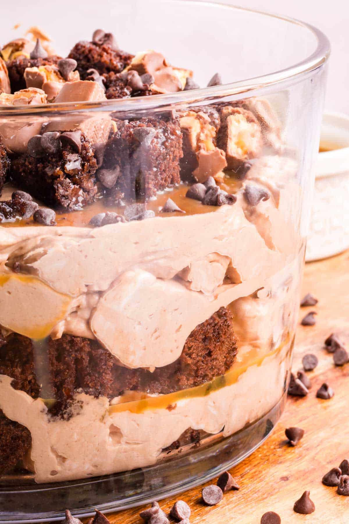 Layers of chocolate cheesecake brownie trifle in a clear serving dish.