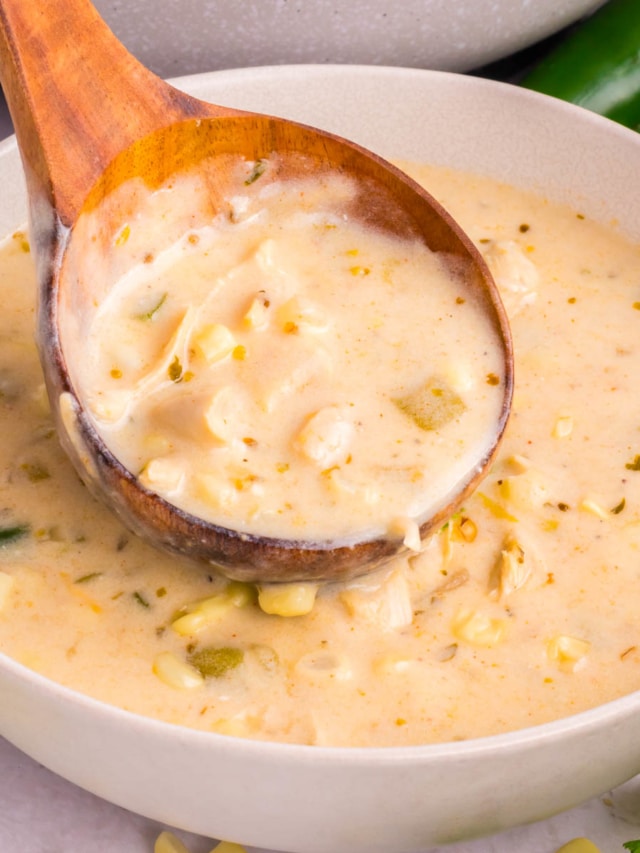 A wooden ladle full of Mexican street corn white chicken chili.