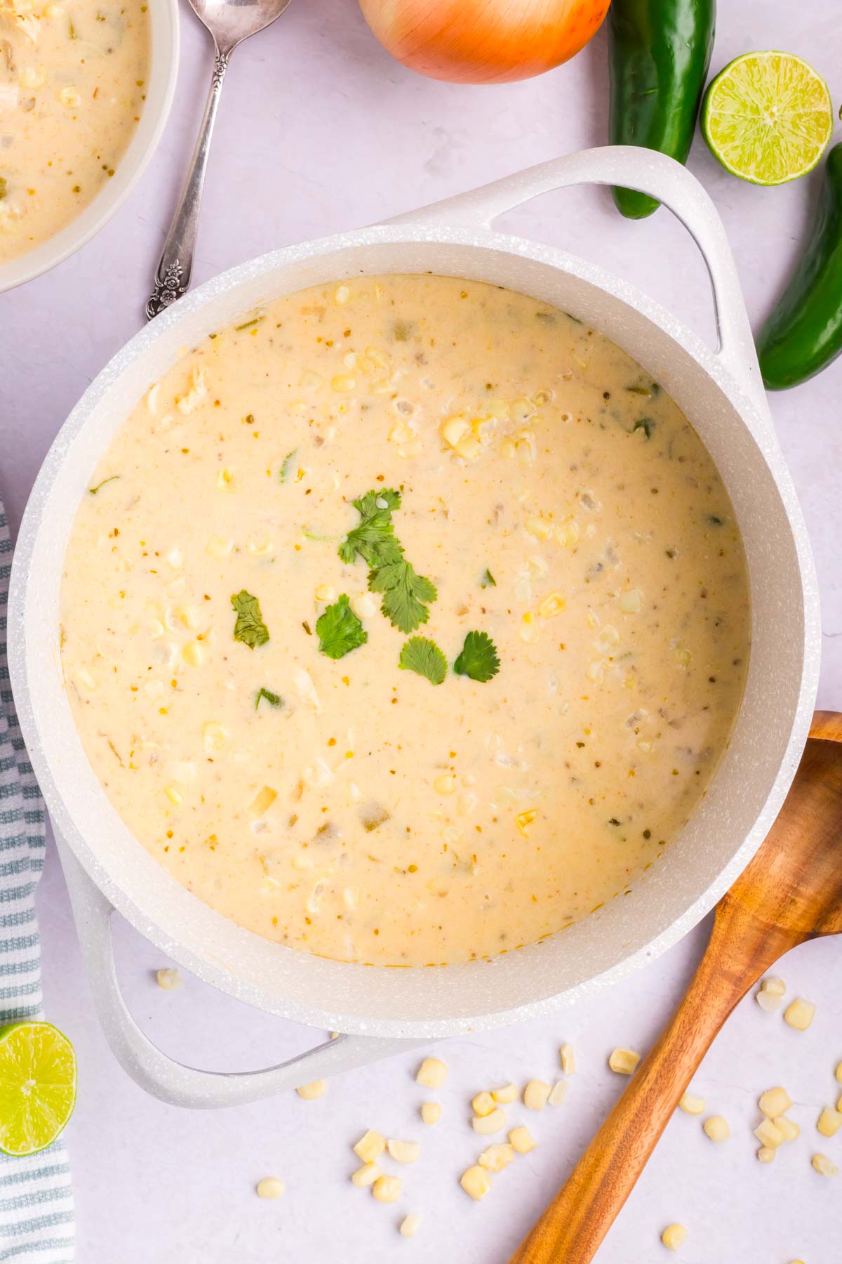 A white pot filled with Mexican street corn soup.