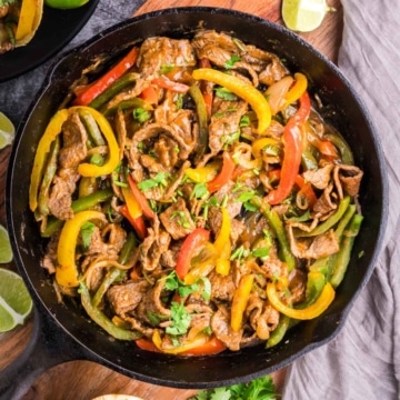 Steak fajitas in a cast iron skillet.