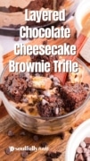 Layered Chocolate cheeesecake brownies trifle in a clear bowl with a serving ready for the table.