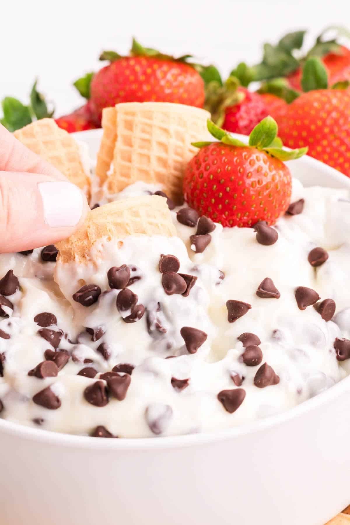 Using a broken waffle cone to dip out a bit of cannoli dip.