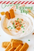Christmas Eggnog Dip image in a white bowl with Lotus cookies and read and green Christmas tree sprinkles.