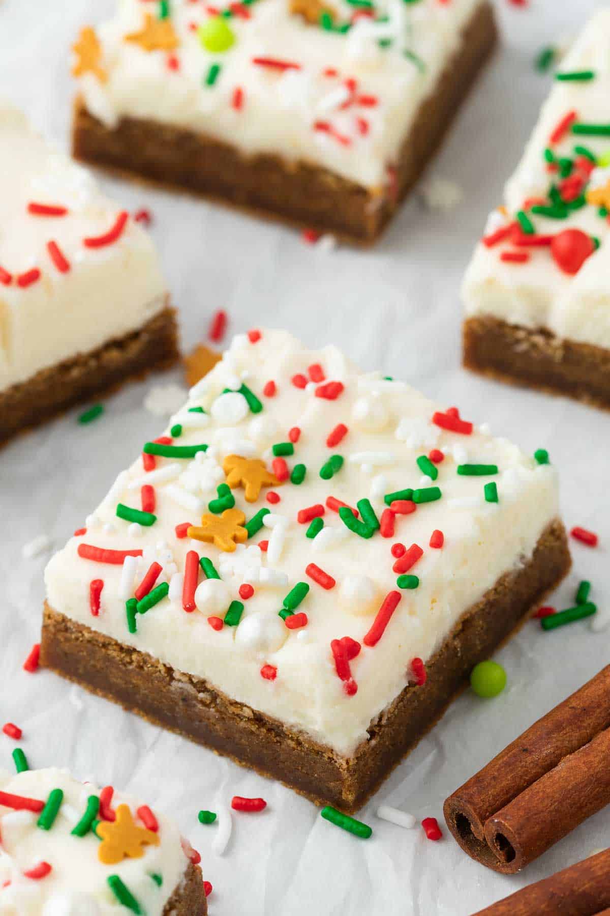 Sliced gingerbread cookie bars with green, white, red and gingerbread sprinkles on top.