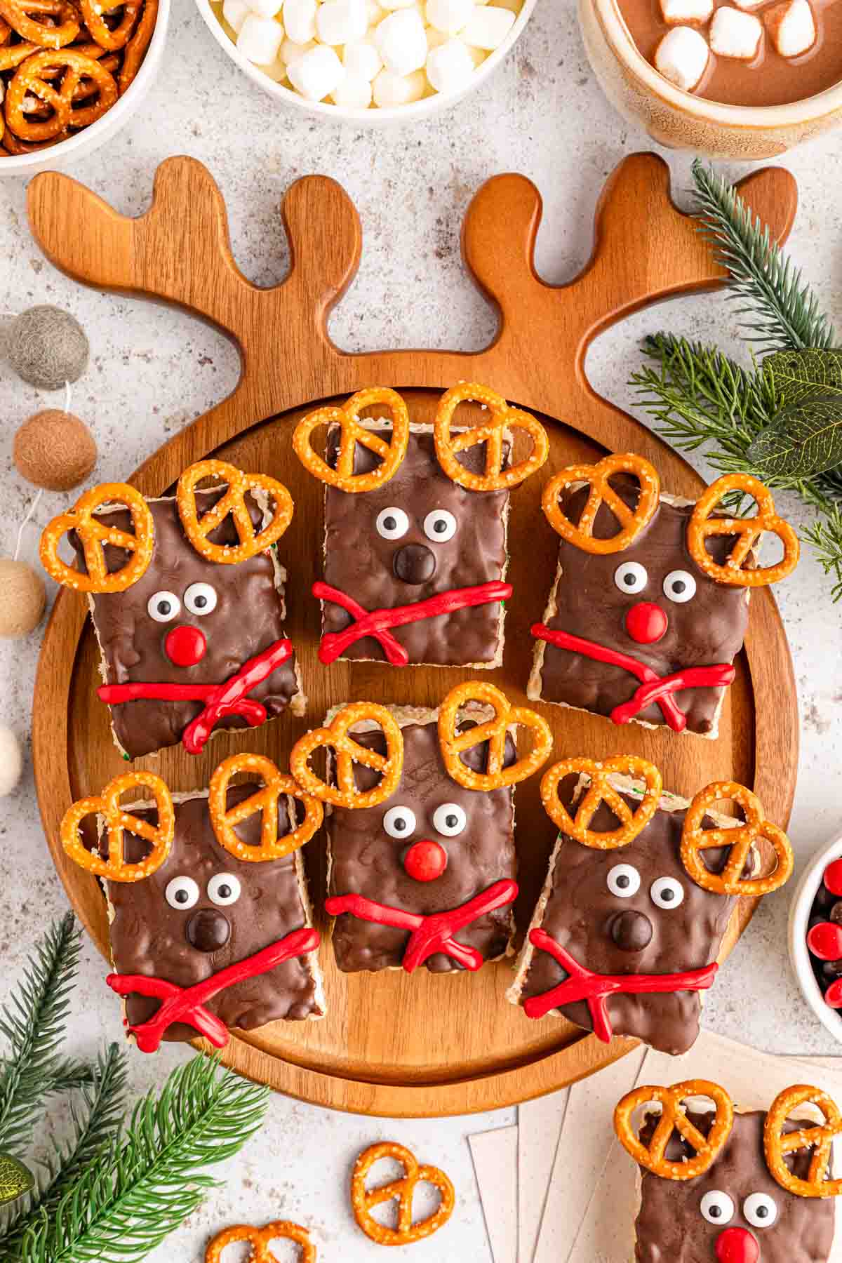 A reindeer shaped wooden tray serving reindeer rice krispies treats.