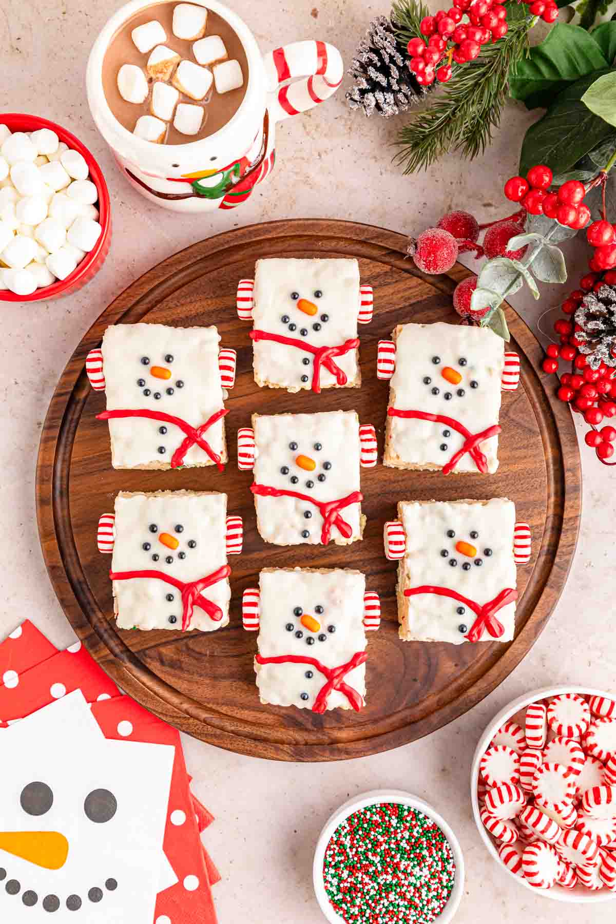 A wooden tray filled with Christmas Snowmen Rice Krispie Treats.
