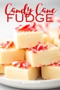 Candy Cane Fudge is a vanilla fudge recipe stacked in cubes on a white plae.