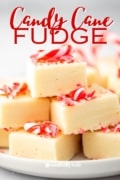 Candy Cane Fudge is a vanilla fudge recipe stacked in cubes on a white plae.