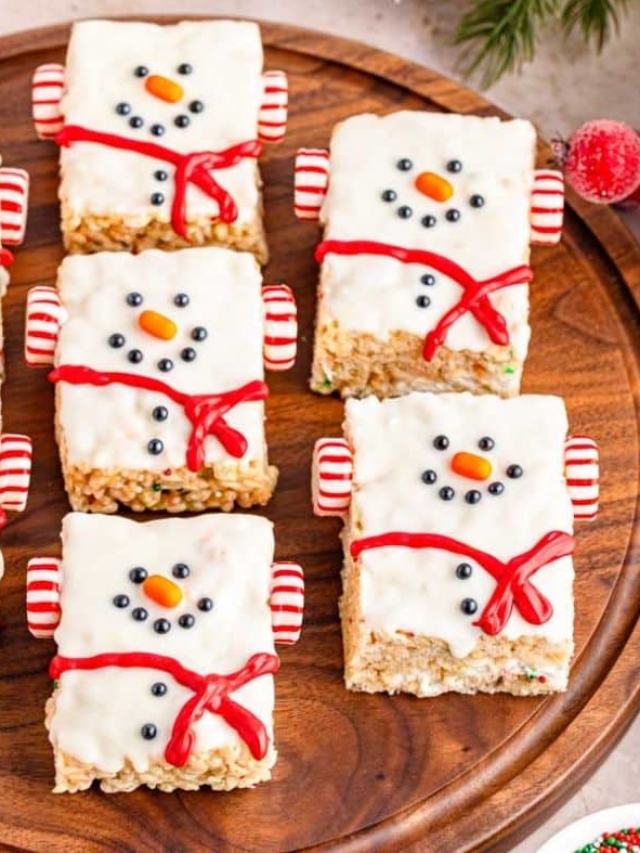 A wood serving tray filled with rice krispie snowmen ready for Christmas.