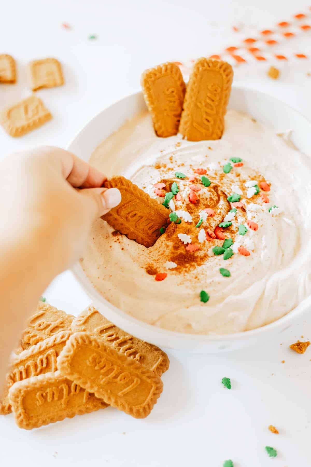 Dipping a cookie into eggnog dessert dip.