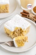 Image only pin for eggnog poke cake with a fork that has taken a bite out and is resting on the plate.