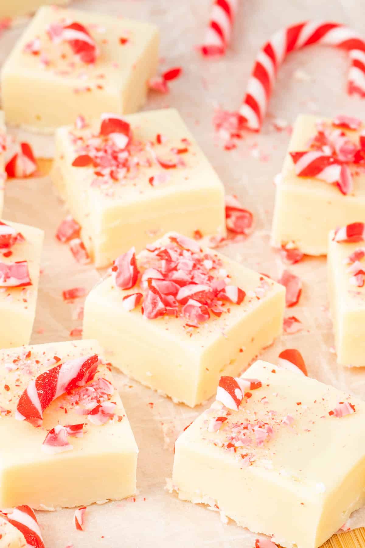 Cut pieces of candy cane fudge on a parchment sheet.