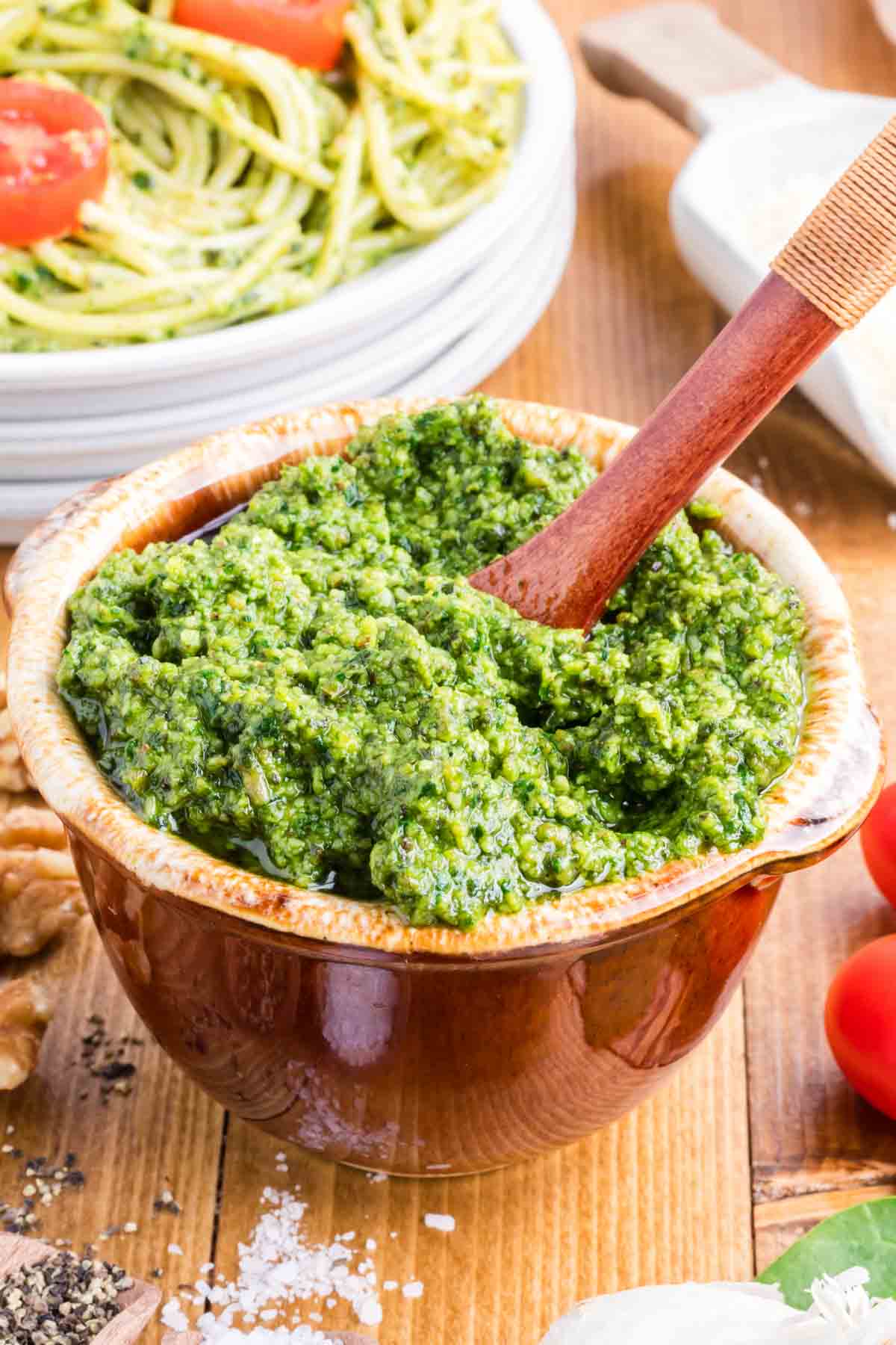 A brown bowl filled with homemade pesto sauce.