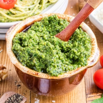 A brown bowl filled with homemade pesto sauce.
