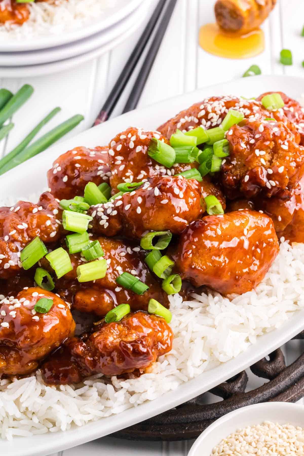 Chinese sesame chicken topped with sliced green onion.