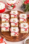 Image and logo shot of a wood platter filled with snowman rice krispie treats.