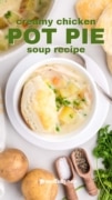 Creamy Chicken Pot Pie Soup image with a fluffy biscuit in the center of the white bowl full.