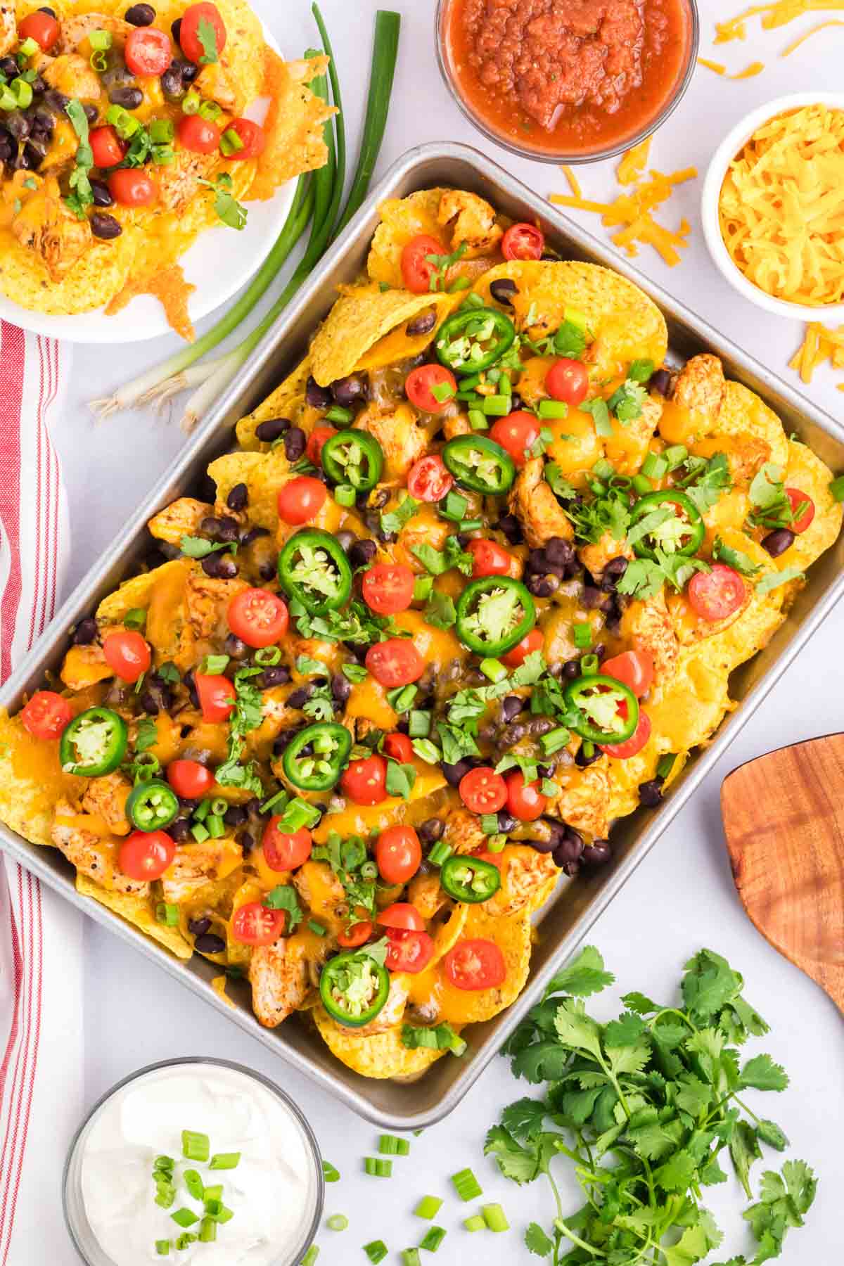Easy Loaded Nachos made with chicken on a sheet pan and topped with your favorite nacho toppings.