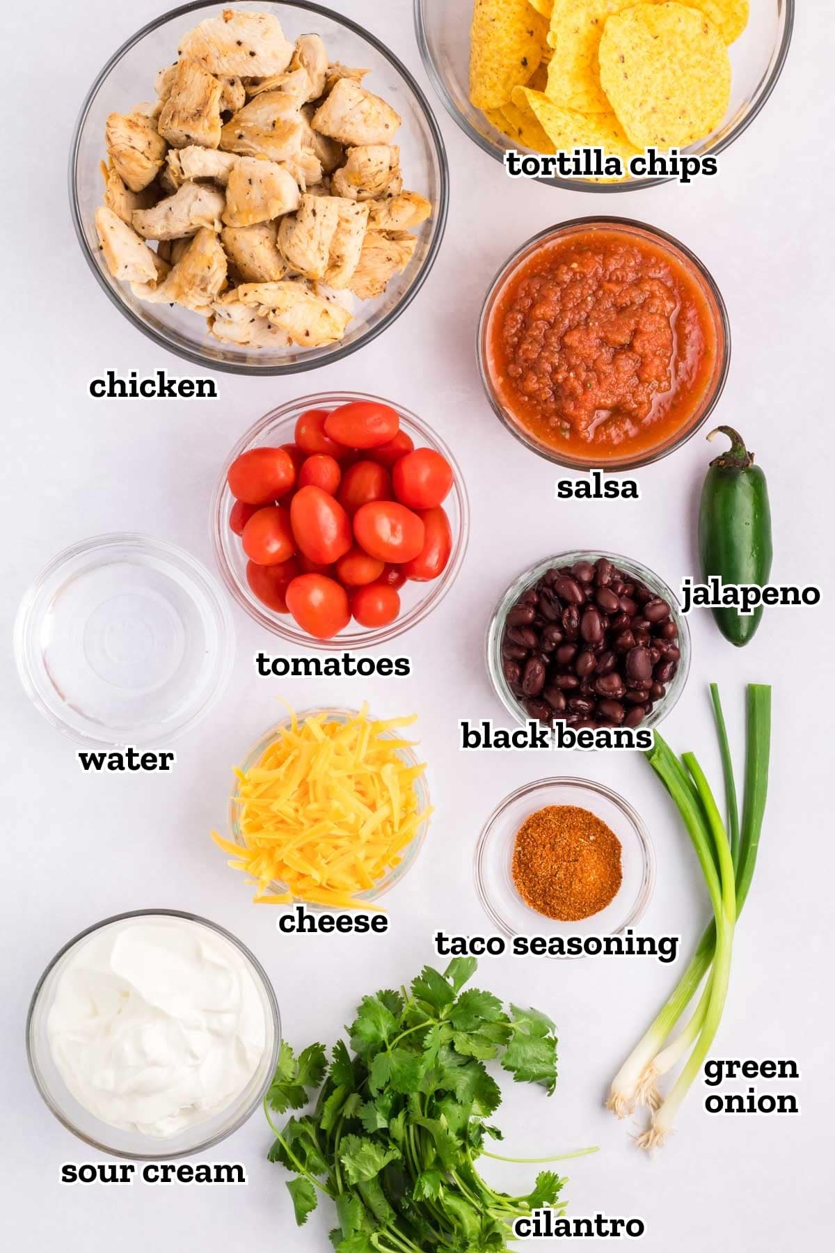 Labeled ingredients needed to make loaded chicken nachos.