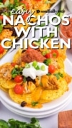 East Nachos with Chicken pictured on a stack of white plates and with a dollop of sour cream on top.