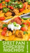 Sheet Pan Chicken Nachos displayed on a stack of white plates with the pan in the background.