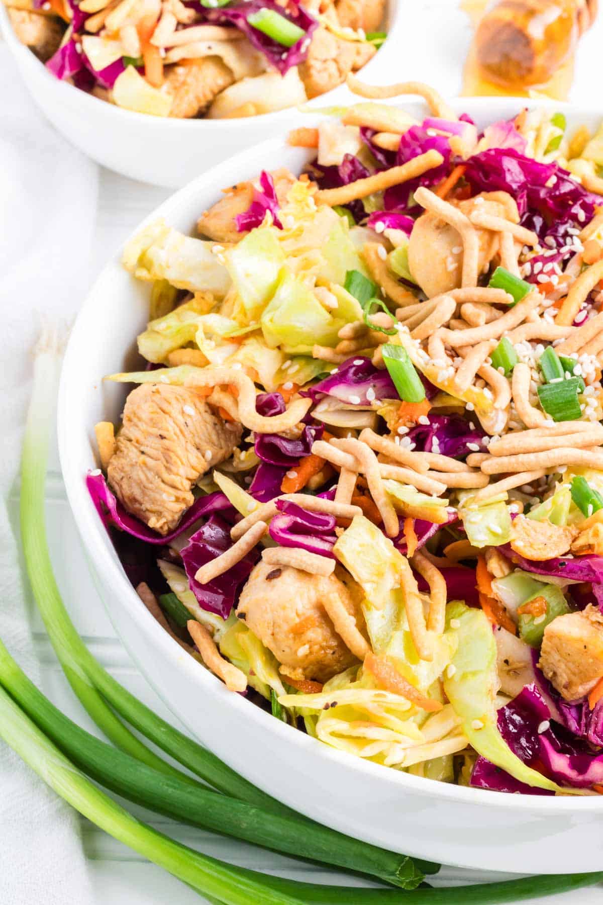 An Asian Chicken salad in a white serving bowl.