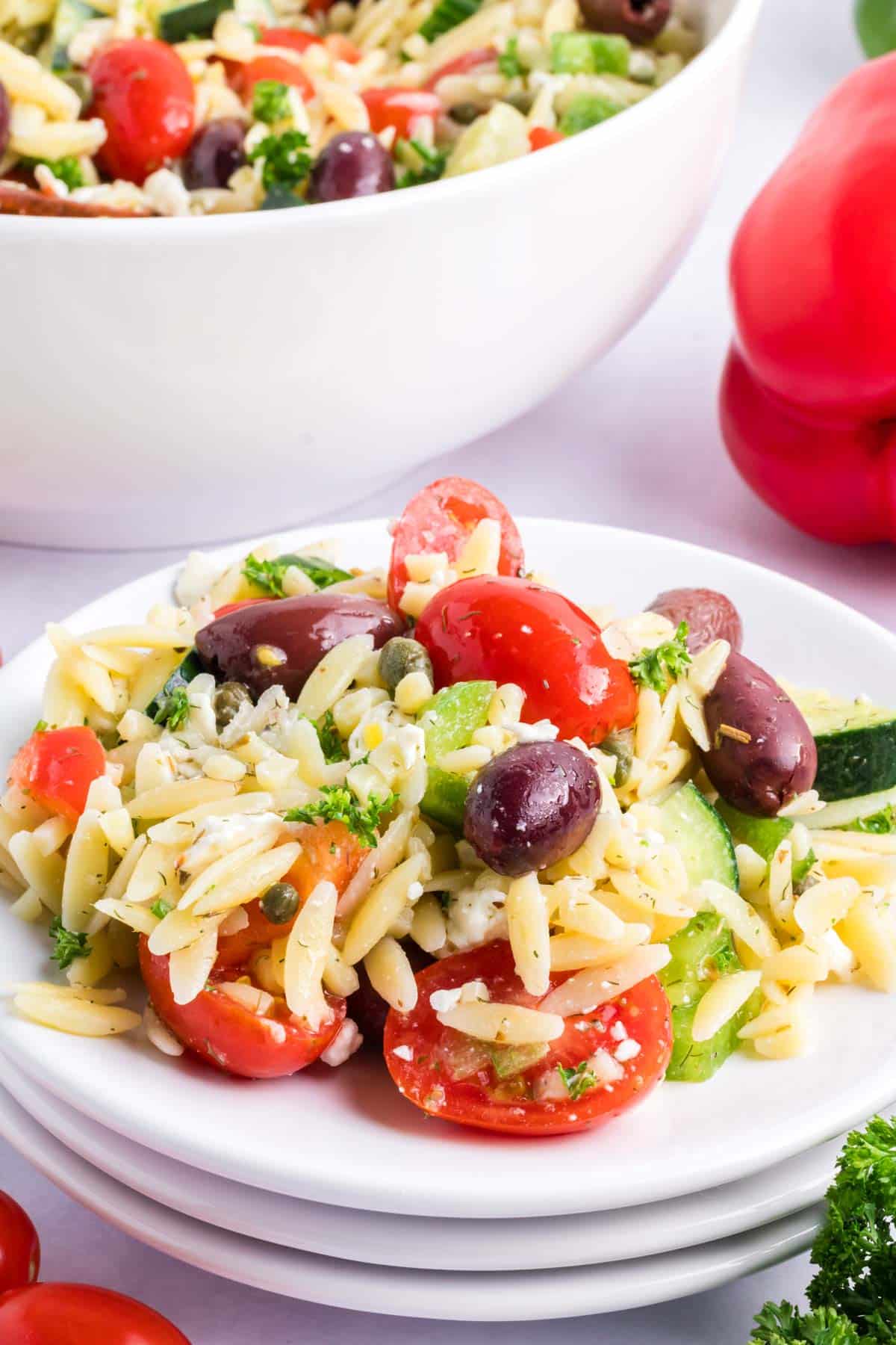 A white plate with a serving of lemon orzo pasta salad.