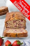 A loaf of Strawberry Banana Bread revealing the inside with a cut slice.