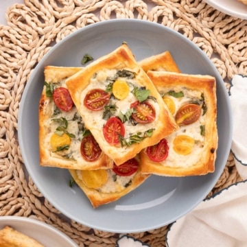 A grey bowl with puff pastry tomato tarts.