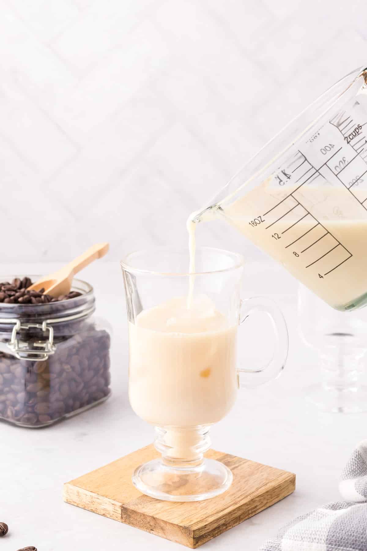 Ice and milk added to a coffee mug.