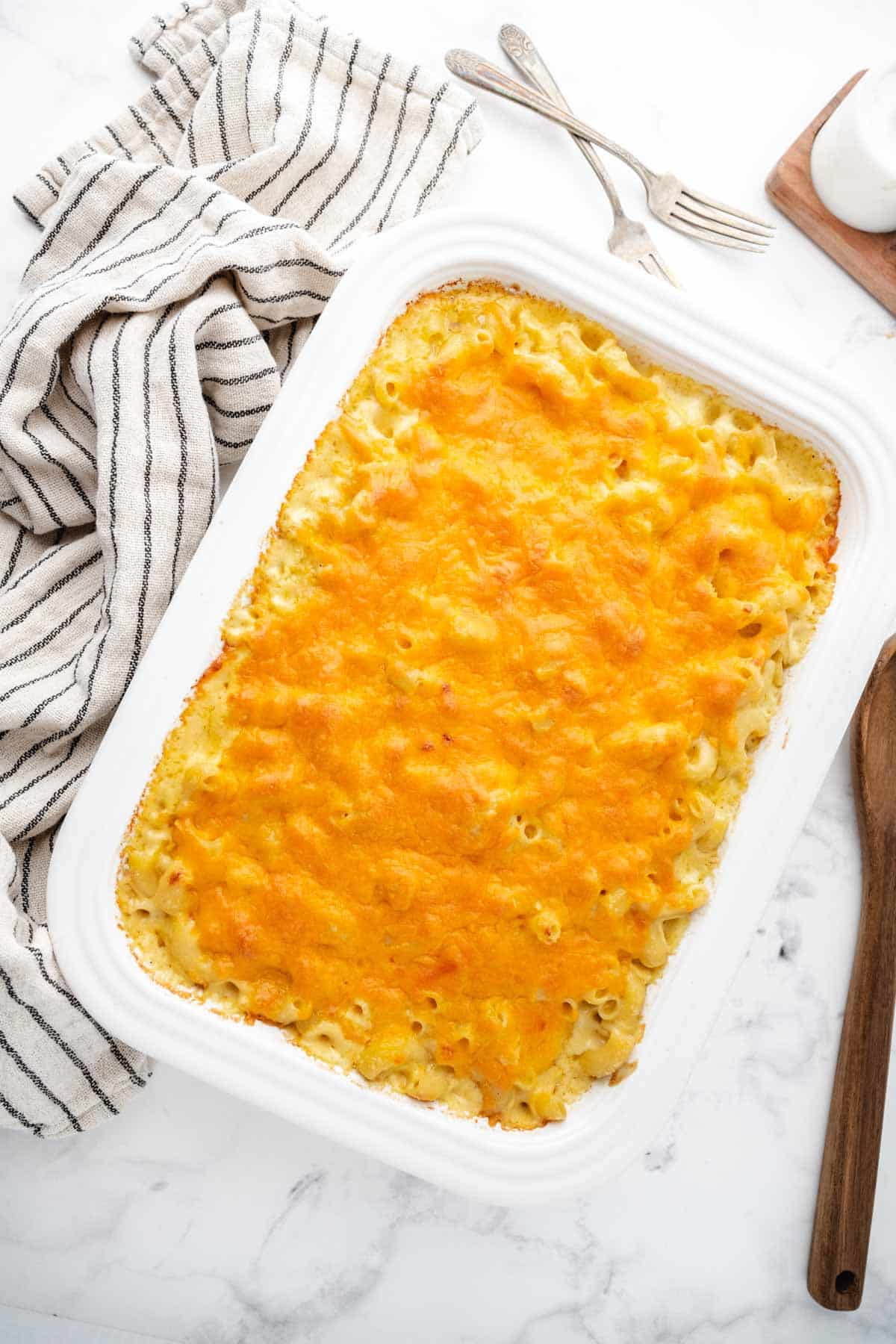 A white casserole dish filled with creamy baked macaroni and cheese.
