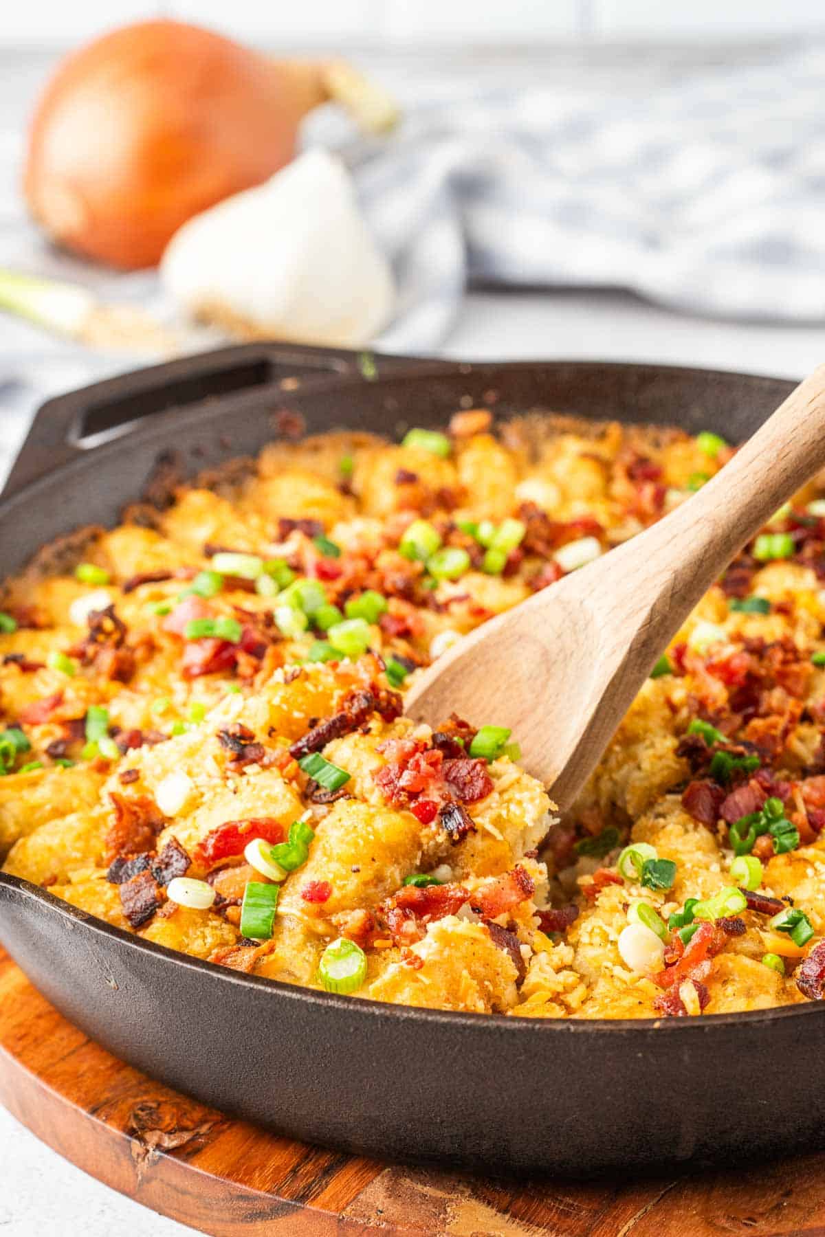 A cast-iron skillet filled with cowboy casserole topped with tater tots.