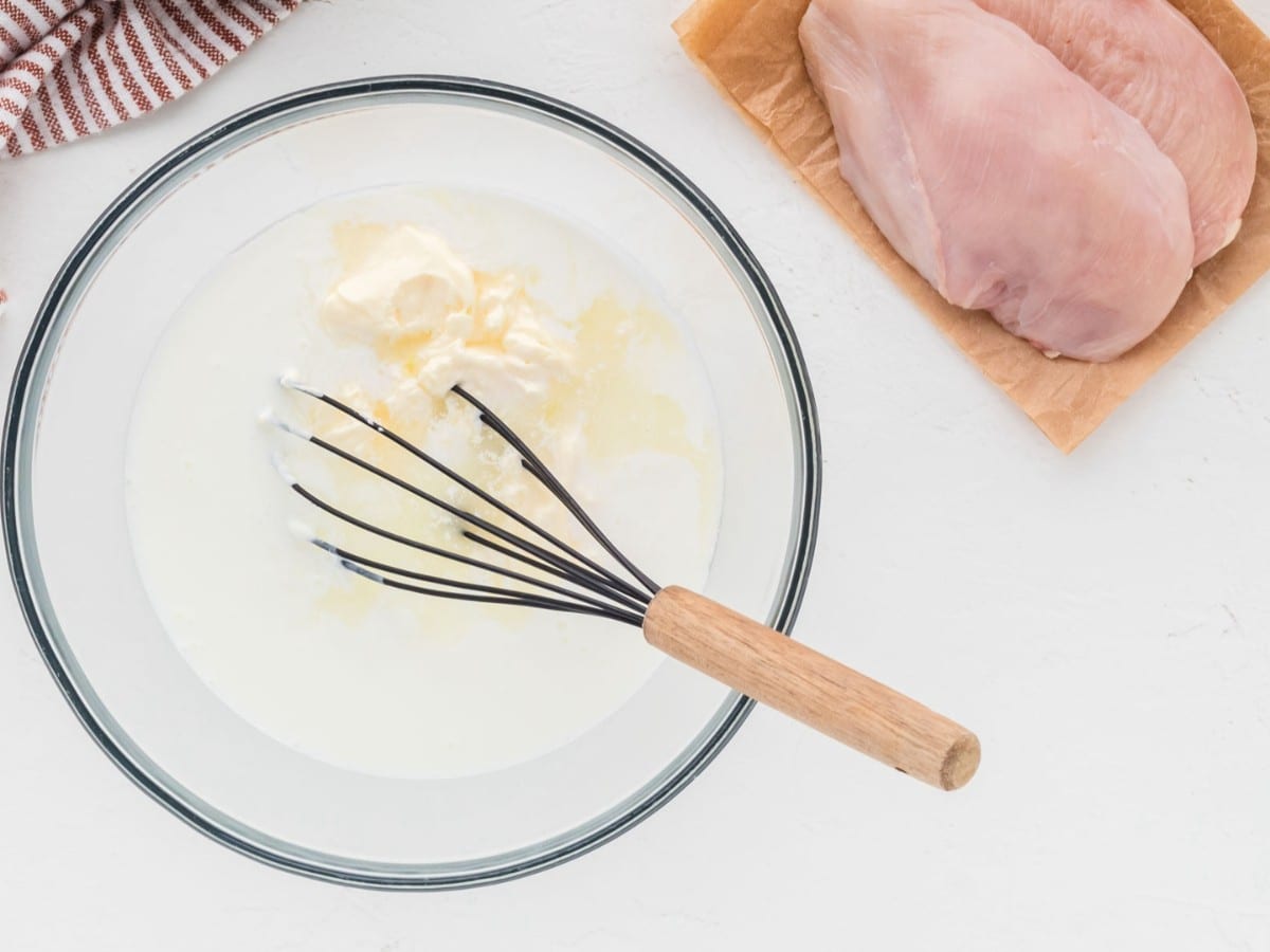 Mayo, buttermilk, and pickle juice in a bowl with a whisk.