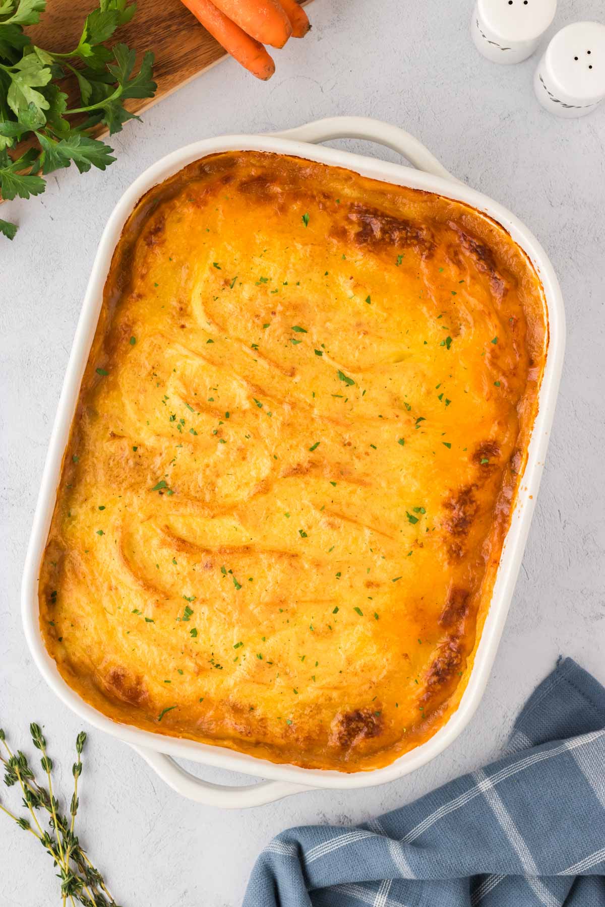A white casserole dish filled with Shepherd's Pie.