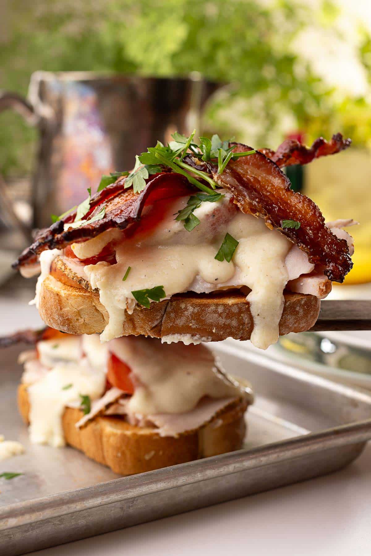 A wood spatula is serving a featured Hot Brown Sandwich.