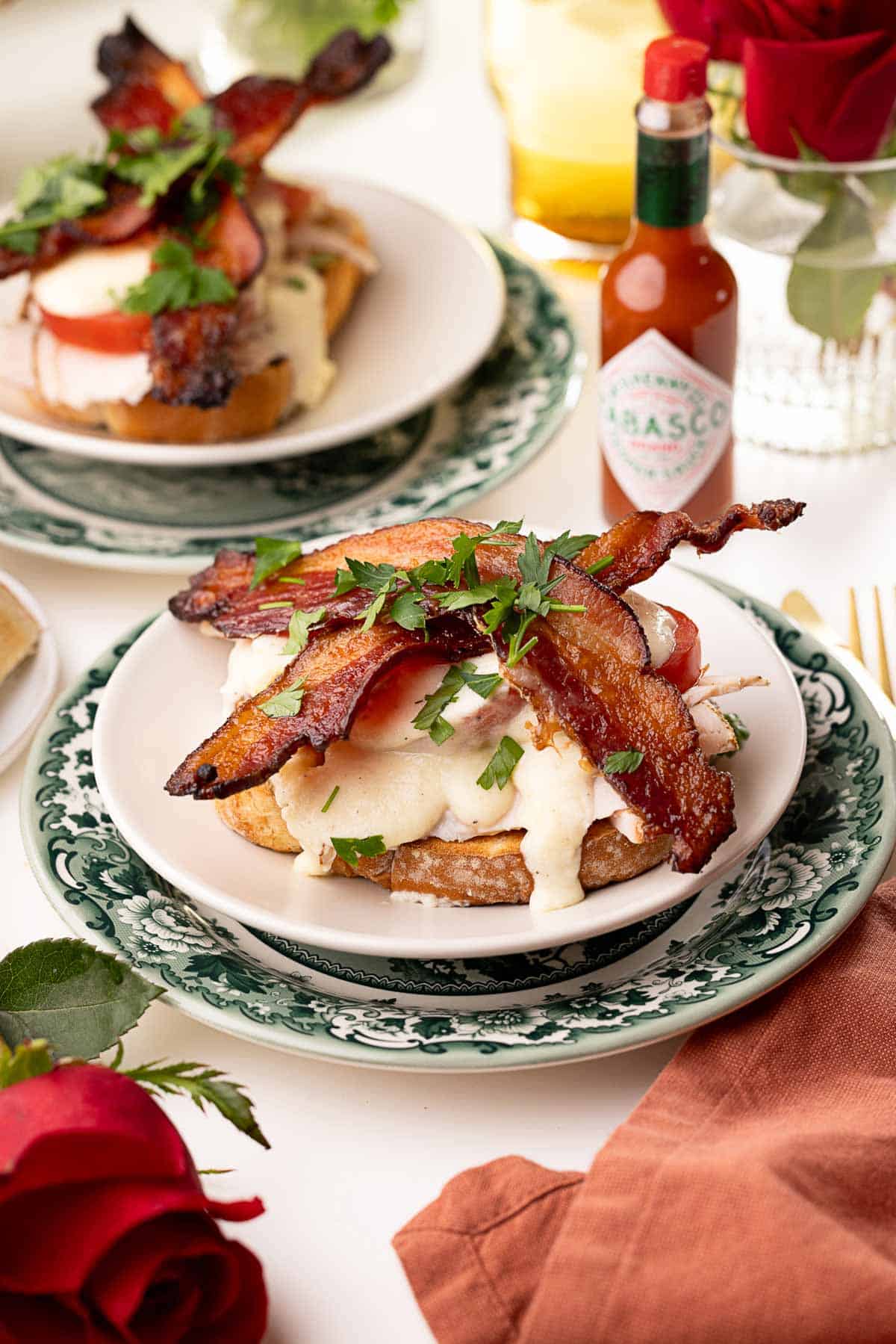 Featured is a piece of Kentucky Hot Brown, with a background of Tabasco sauce and another plate.