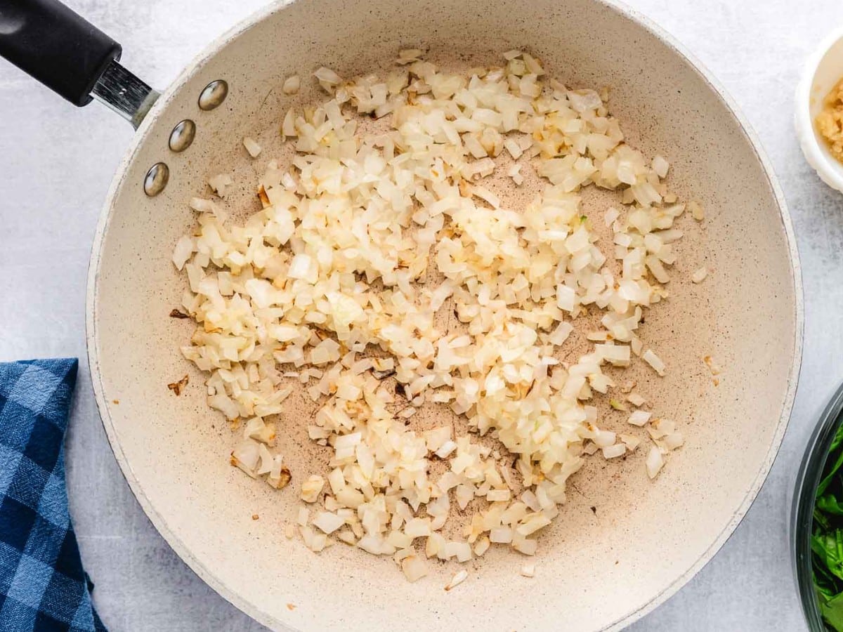 Onions cooked down in a skillet.