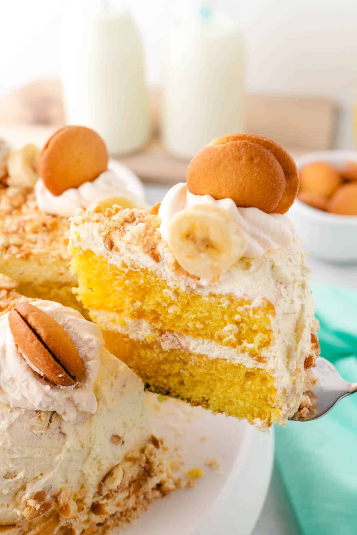 A spatula removing a slice of banana pudding cake from the whole cake.