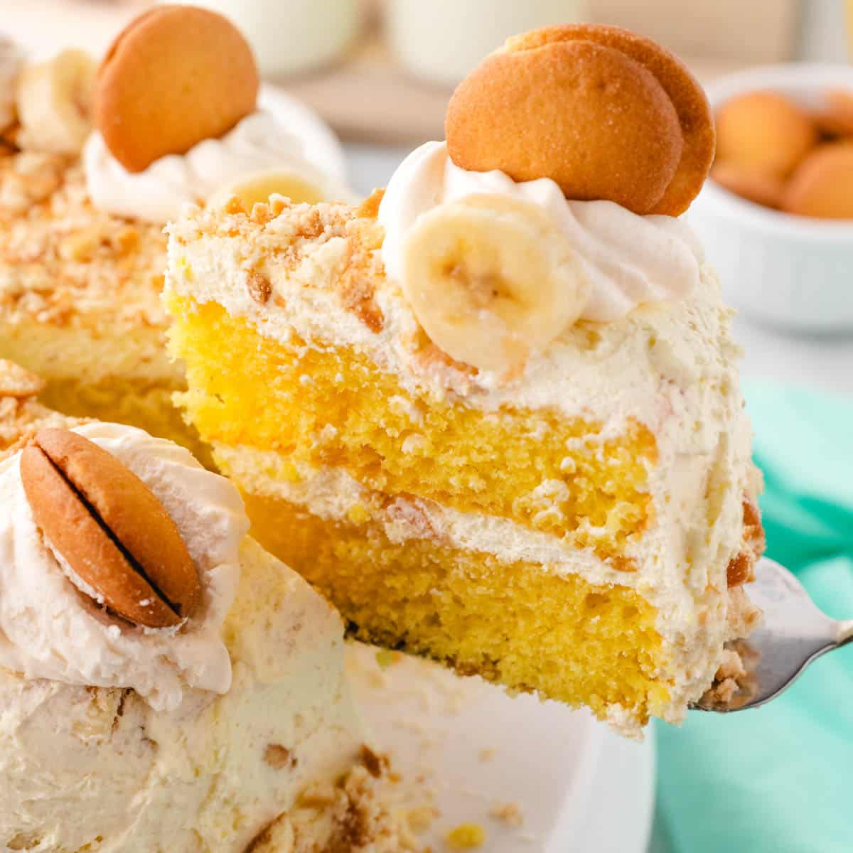 A spatula removing a slice of banana pudding cake from the whole cake.