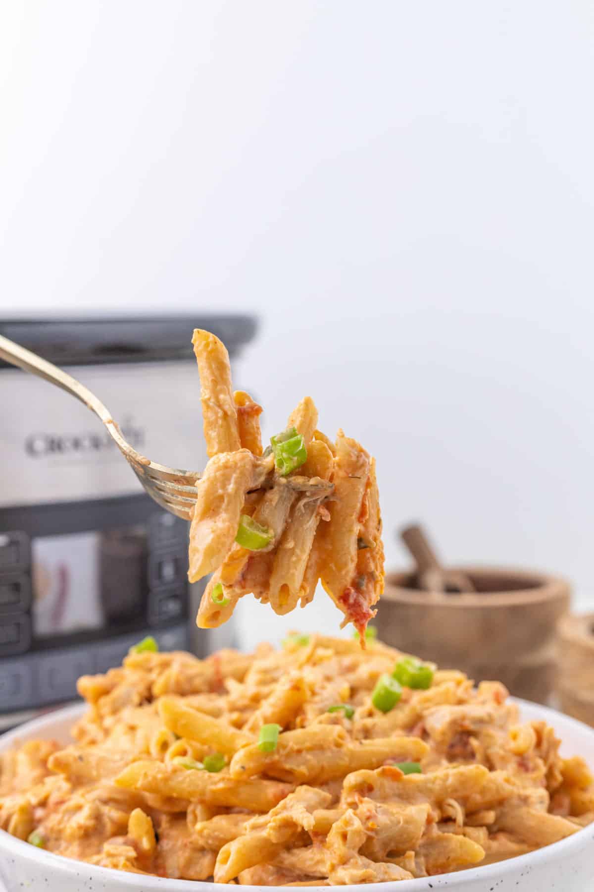 A silver fork picking up a bite of buffalo chicken pasta.