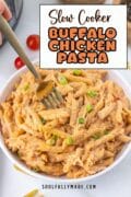 Slow Cooker Buffalo CHicken recipe is on a white dinner bowl with a fork ready to take out a bite.