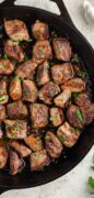 Garlic butter steak bites image only shot from overtop showing the tender steak bites in a skillet.