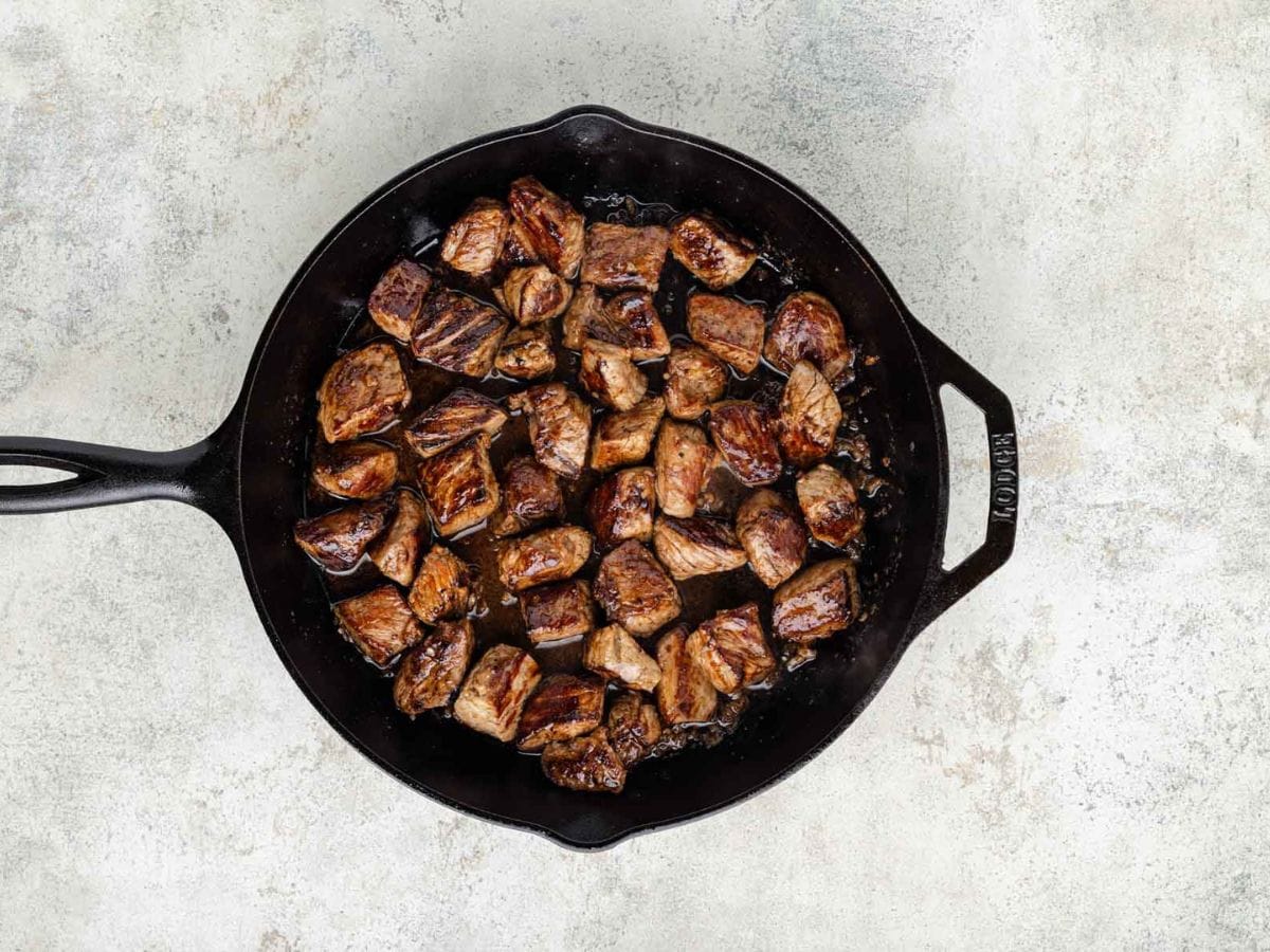 Searing steaks in a cast iron skillet.