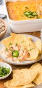 Black eyed pea dip is showing a serving on a plate and the entire casserole dish full and topped with cheese.