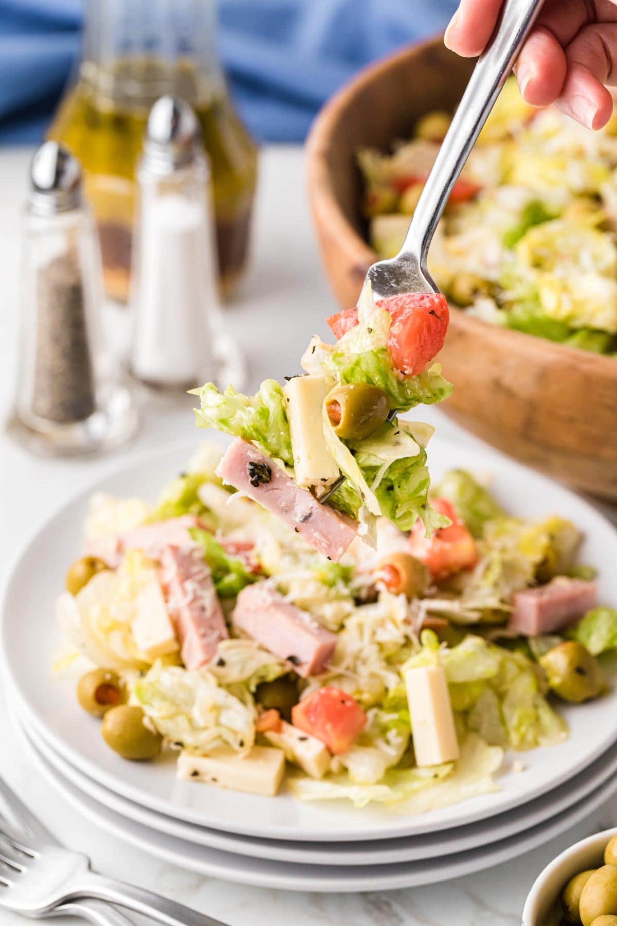A salad with a bite removed with a fork.