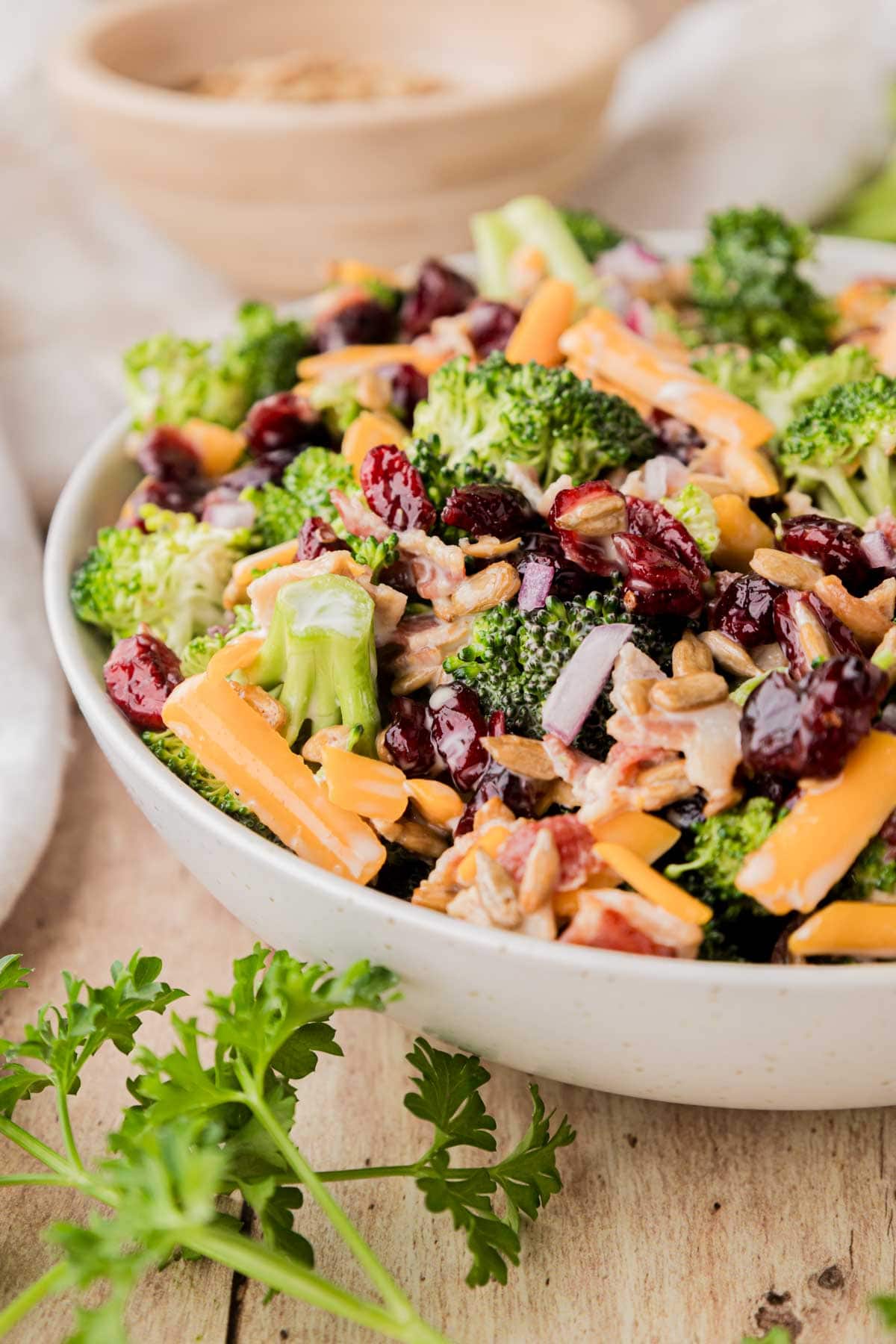 Close up of broccoli salad with bacon in a large white bowl.