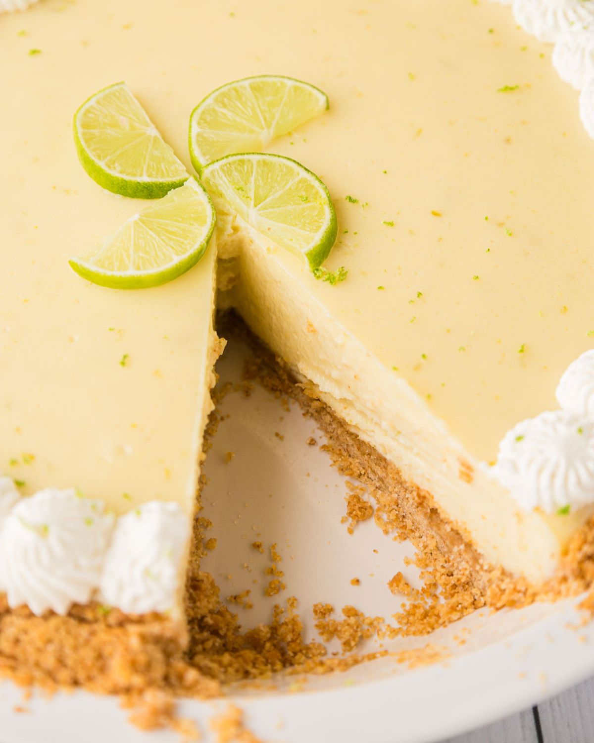 A graham cracker crust key lime pie sliced.